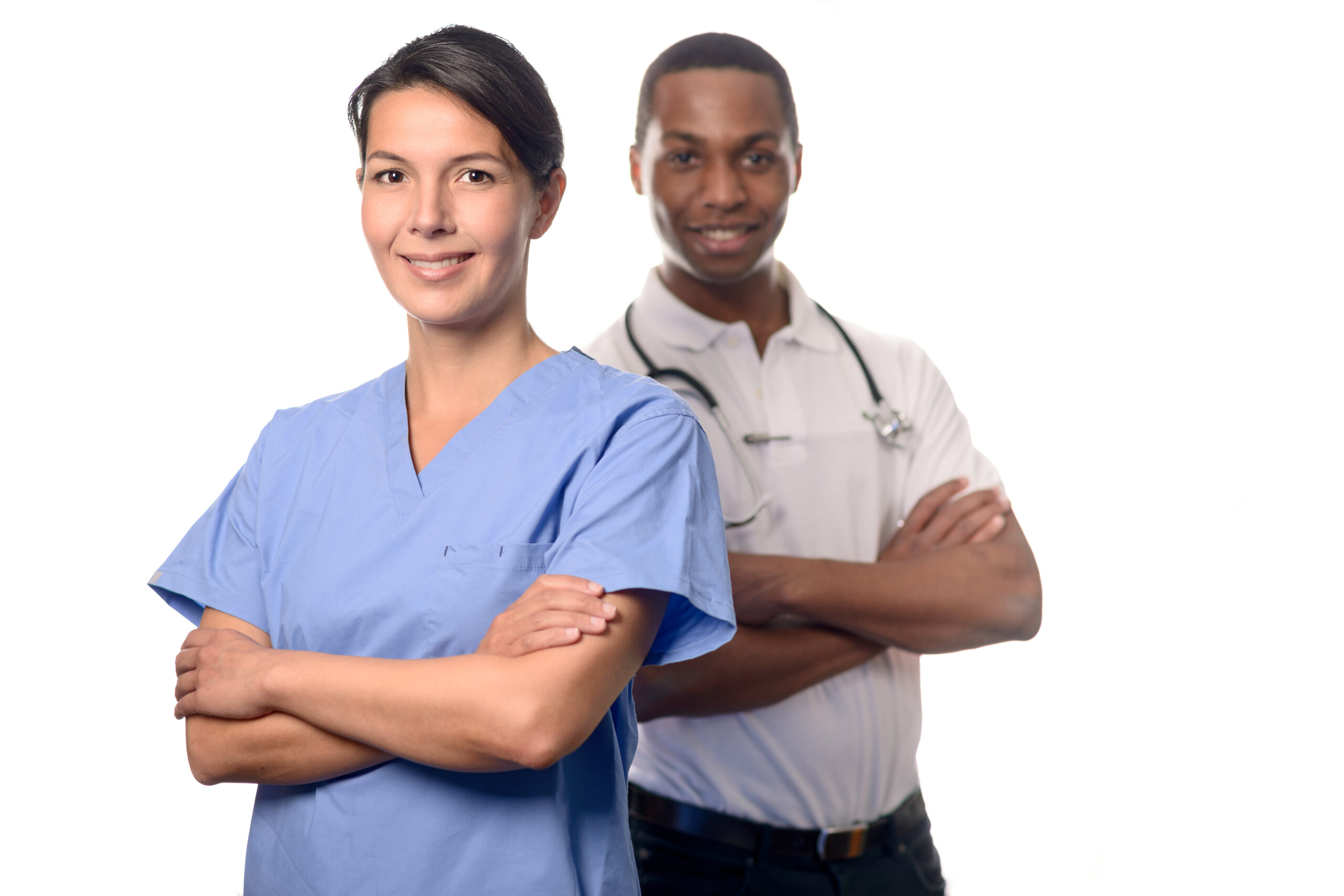 Successful attractive female doctor or surgeon in scrubs standing with folded arms in front of an African male doctor or consultant conceptual of an expert medical team, on white